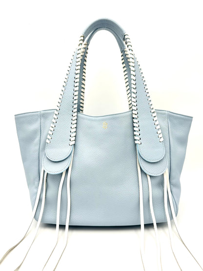 The Talitha tote handbag from The Furies Collective in Sky Blue with lacing in Snow — pebble leather with whipstitched fringe handles and the Furies snake logo.
