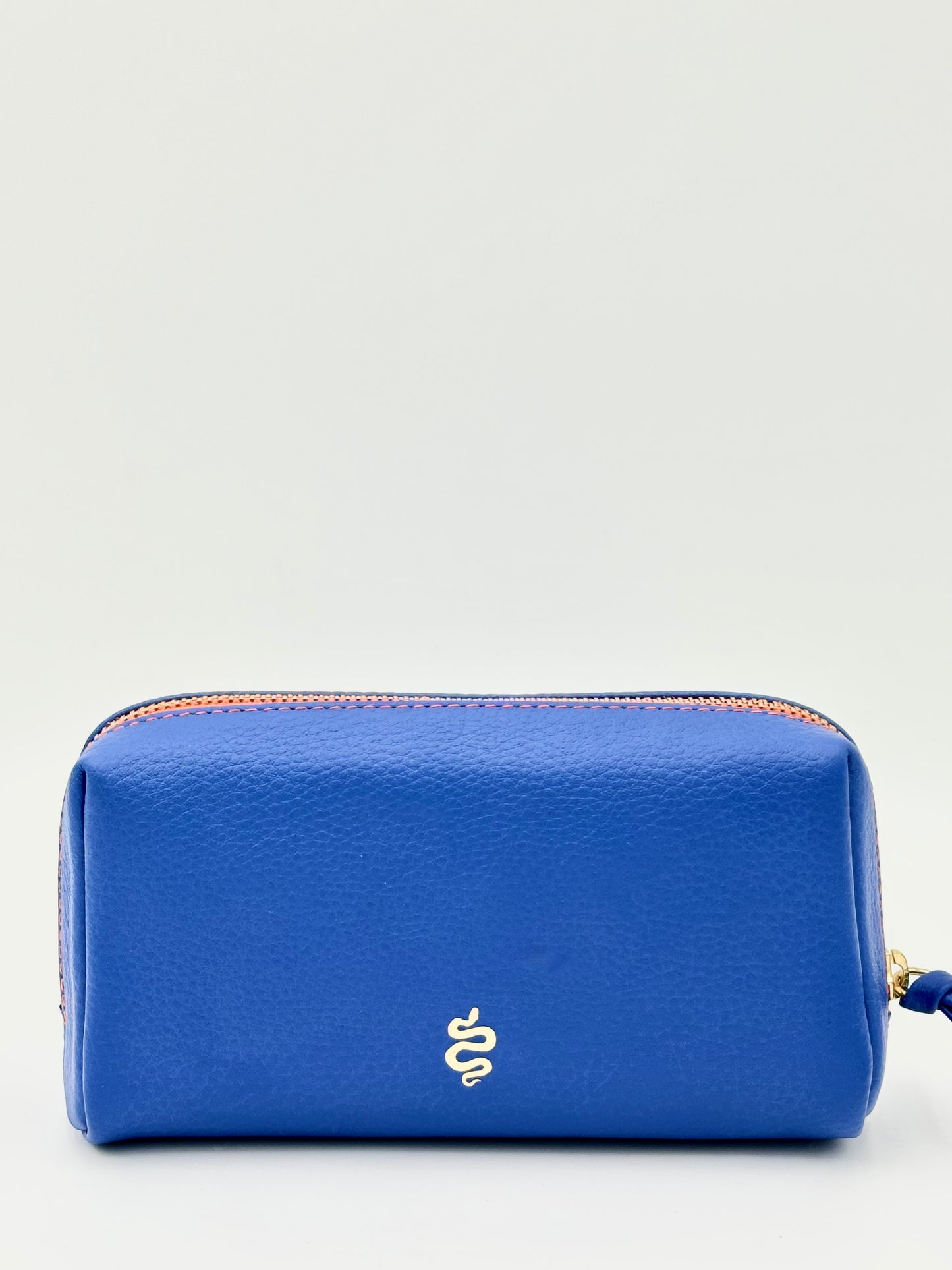The Small Makeup Bag from The Furies Collective in Sapphire with a Bright Orange Interior — pebble leather pouch with brass zipper for cosmetics.