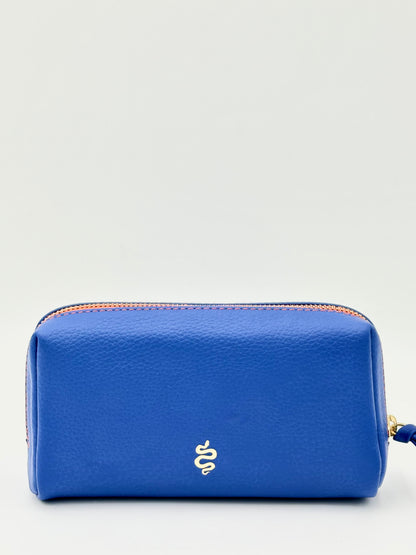 The Small Makeup Bag from The Furies Collective in Sapphire with a Bright Orange Interior — pebble leather pouch with brass zipper for cosmetics.
