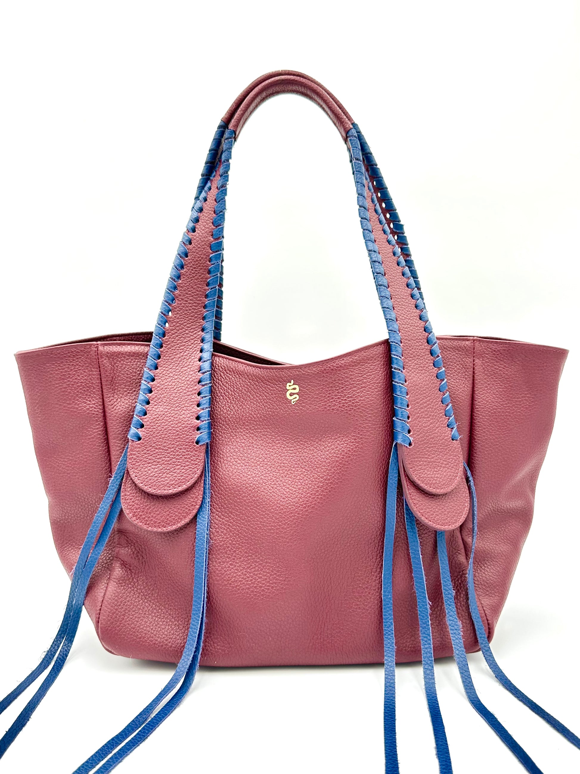 The Talitha tote handbag from The Furies Collective in Claret with Navy Lacing — pebble leather with whipstitched fringe handles and the Furies snake logo.