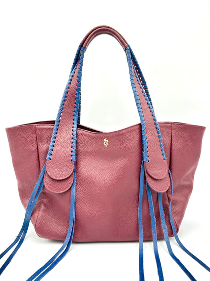 The Talitha tote handbag from The Furies Collective in Claret with Navy Lacing — pebble leather with whipstitched fringe handles and the Furies snake logo.