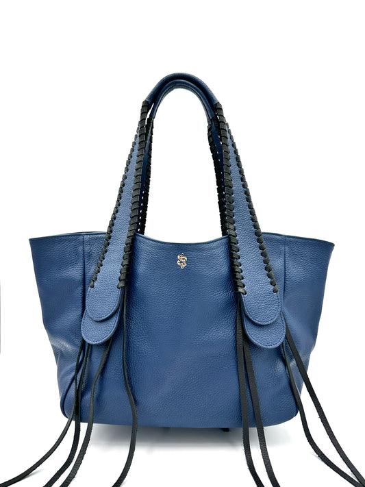 The Talitha tote handbag from The Furies Collective in Navy with Black Lacing — pebble leather with whipstitched fringe handles and the Furies snake logo.