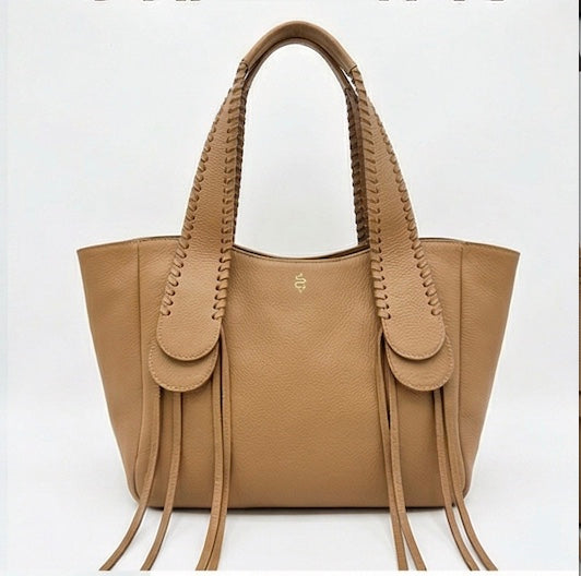 The Talitha tote handbag from The Furies Collective in Cognac — pebble leather with whipstitched fringe handles and the Furies snake logo.