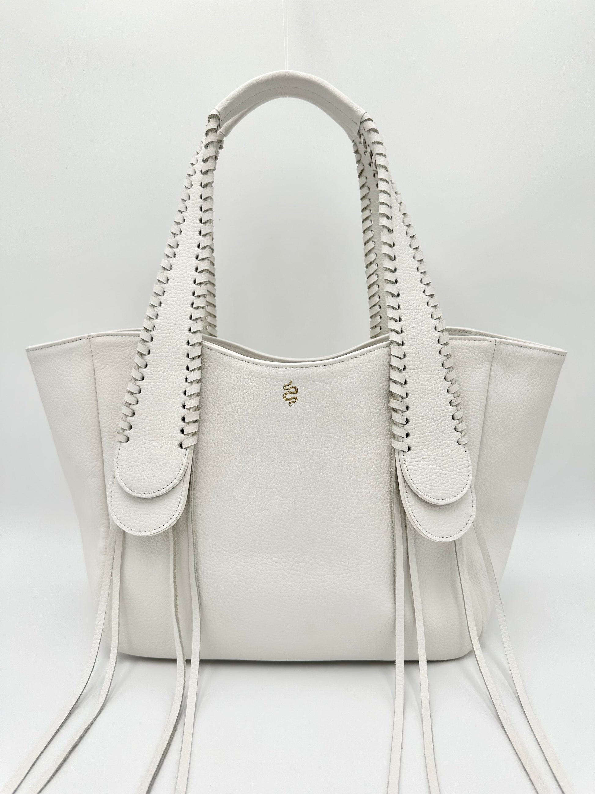 A white pebble leather handbag with whipstitched detailing on the handles and a fringe design, viewed from the front and snake logo